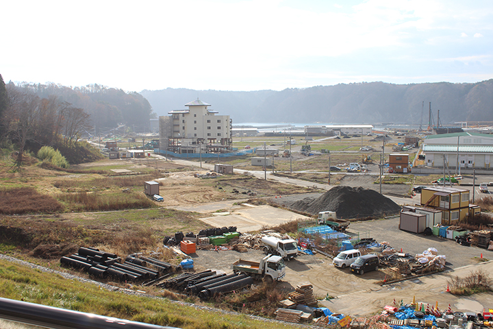 現在の田老町。高台の斜面を削って新たな町が作られています。 遠くに津波の被害を受けた「たろう観光ホテル」が確認できます。